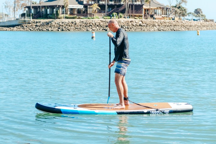 a man riding on the back of a boat in the water